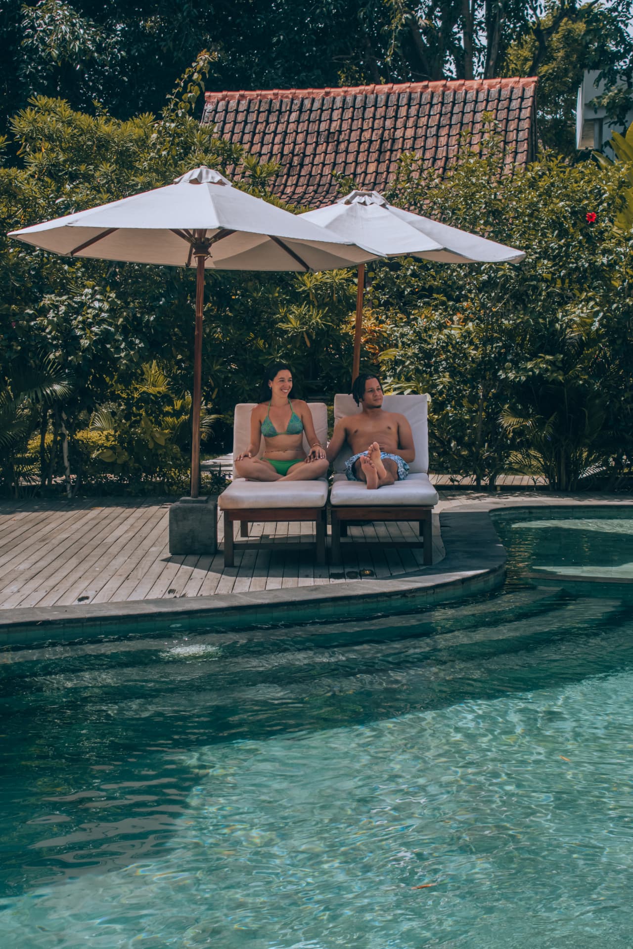 Couple au bord d'une piscine tropicale